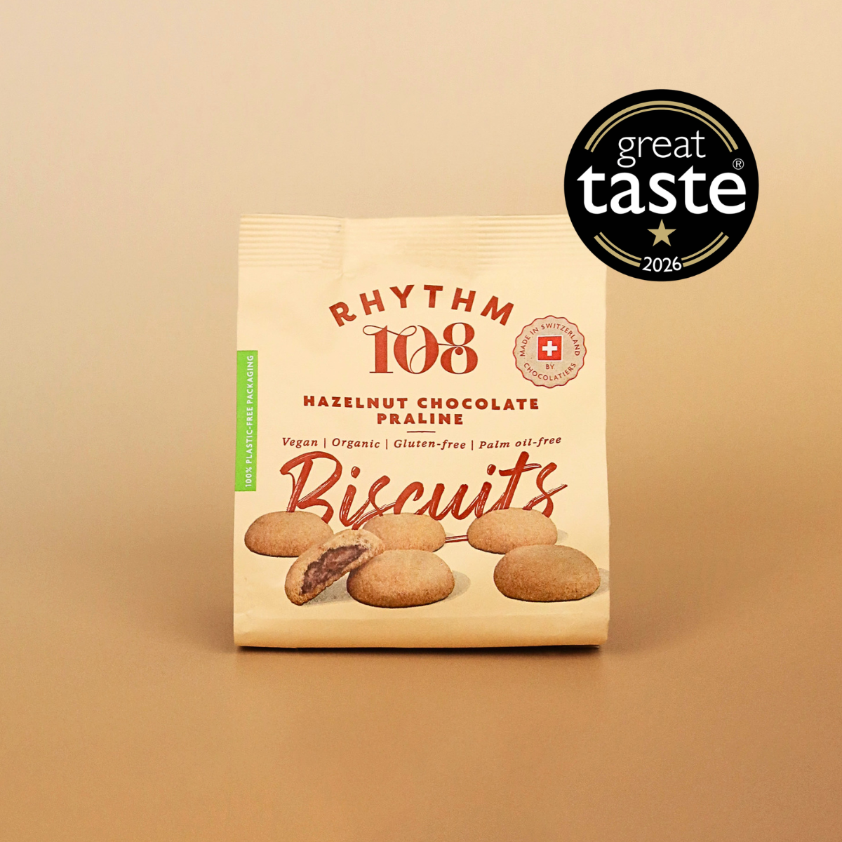 A package of Rhythm 108 Hazelnut Chocolate Praline Biscuits on a warm beige background, featuring a black 'great taste 2026' award badge in the top right corner.